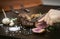 Slicing organic roast beef roll on wood table with ingredients