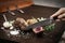 Slicing organic roast beef roll on wood table with ingredients