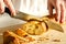 Slicing tasty, fresh, crisp bread. Beautiful female hands, a knife for cutting bread and sliced baguette closeup. Floury