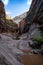 Slick sandstone canyon walls and muddy puddles along the Observation Point hiking trail in Zion National Park