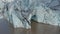 Slide and pan aerial shot of ice blocks on front of glacier standing in water. Arctic nature scenery. Iceland