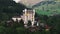 Slide and pan footage of multistorey buildings with turrets and alpine meadows in background. Luxury hotel complex in