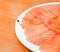 Slided Raw Salmon in white dish on wood blackground