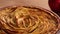 Slider shot of rotating golden apple pie on rustic wooden table, traditional food of the fall season. Thanksgiving recipes