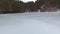 Sliding on the ice of a frozen lake. Movement to the wooded shore. Overcast weather
