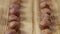 Sliding shot of dried hazelnuts lying in row on textured wooden table surface. Close up whole brown hazel kernels form