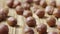 Sliding shot of dried hazelnuts lying on a textured wooden table surface. Close up whole brown kernels hazel are