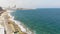 Sliema rocky seascape blocked by Promenade and city skyline, in Malta - Revealing Pan aerial