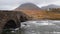 The Sligachan Old stone Bridge over River Sligachan with Beinn Dearg Mhor and Marsco peak of Red Cuillin mountains in