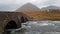 The Sligachan Old stone Bridge over River Sligachan with Beinn Dearg Mhor and Marsco peak of Red Cuillin mountains in