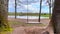 Slightly moving empty wooden swing summer spring outdoor. Sunny day and blue sky. Calmness. No people.