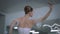 Slim agile ballerina in white dress spinning as live camera moves around ballet dancer rehearsing in studio