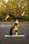 Slim athletic woman doing exercise handstand in the stadium, sporty girl workout, outdoors