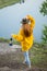 Slim attractive girl in stylish raincoat lightning the top of mountain