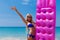 Slim blonde woman with air mattress tropic beach