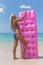 Slim blonde woman with air mattress tropic beach