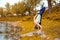 Slim brunette girl goes in for sports and performs yoga poses in the fall in nature by the lake