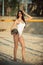 Slim brunette woman is wearing white fashion swimsuit is playing beach volleyball, summer vacations