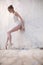 Slim dancer stands in a ballet pose