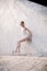Slim dancer stands in a ballet pose