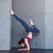 Slim female yogi wearing sportswear performing inversion or arm balance standing upside down on forearms