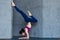 Slim female yogi wearing sportswear performing inversion or arm balance standing upside down on forearms