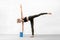 Slim fit caucasian woman practice yoga balance drill using brick in fitness studio indoor.