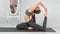 Slim fitness woman showing perfect stretching on mat at white room interior
