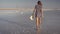 Slim girl enjoying a sunset, gently walks on the water of a salt lake