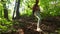 Slim girl hiking downhill in sunny forest. 4K steadicam shot