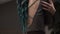slim girl hugging themselves in the bohemian room. Painted turquoise hair. Close-up. Beautiful back