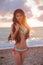 Slim girl model in bikini enjoying sunset on the beach with beau