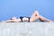 Slim girl in one-piece swimsuit sunbathes on seafront