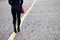 Slim girl in spring clothes walking on the yellow line on a street, rear view