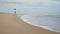 Slim girl walking ocean shore on gloomy day. Relaxed african american woman rest