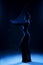 Slim girl wearing a white bodysuit dances a modern avant garde dance, covering her body with elastic transparent fabric in blue