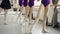 Slim girls` legs in tights are doing battement tendu during ballet lesson with experienced female teacher demonstrating