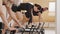 Slim good looking senior woman doing core exercises while taking pilates lesson on a reformer machine, by female