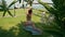 Slim gorgeous young yogi stretching in warrior one pose on exercise mat outdoors. Side back view of Caucasian woman in