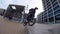 Slim guy bmx biker makes ollie tricks and 360 rotation in city park on sunny day