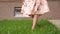 Slim lady in dress bare feet walk along fresh green grass