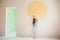 Slim little caucasian girl touching sun painted on wall in new room of house