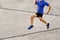slim muscular male runner running concrete road