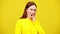 Slim redhead woman yawning at yellow background. Portrait of tired or bored beautiful Caucasian lady. Exhaustion and
