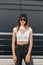 Slim sexy beautiful young hipster girl in fashionable dark sunglasses in stylish youth summer clothes from new collection and