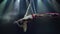 Slim and sexy female Aerial acrobat on the stage with aerial hoop with spot lights on background