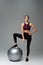 slim sportswoman stepping on fitness ball