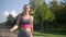 Slim sporty woman walking in park after jogging