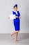 Slim stewardess in blue uniform in full height with white sheet of paper