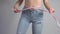 Slim woman in blue jeans measuring her perfect waist after successful weight loss